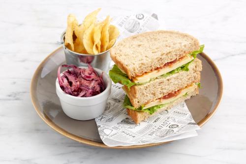 a sandwich on a plate with a cup of fries at Holiday Inn Norwich City by IHG in Norwich