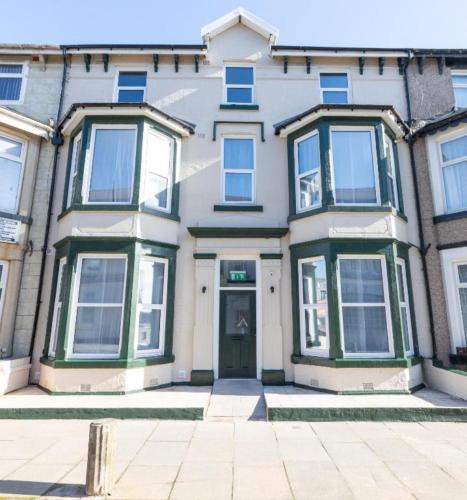 a large white house with green windows and a door at Charles Alexander Short Stay - TheWestern Blackpool in Blackpool