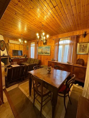 a dining room with a table and a couch at Villa Ikaros Ag Apostoloi Attica in Mesochórion