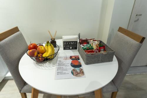 a table with a bowl of fruit and a basket of produce at N&M Apartment in Chios