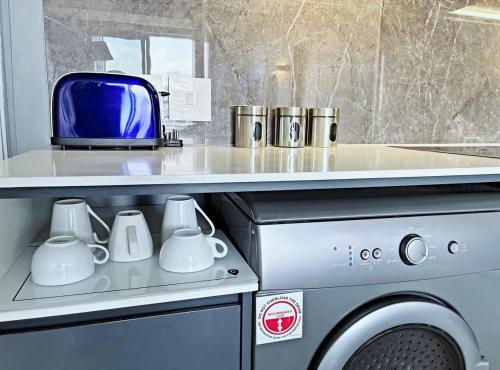 a kitchen with a washing machine and a toaster at Stunning City View Apartment Sandton City in Johannesburg