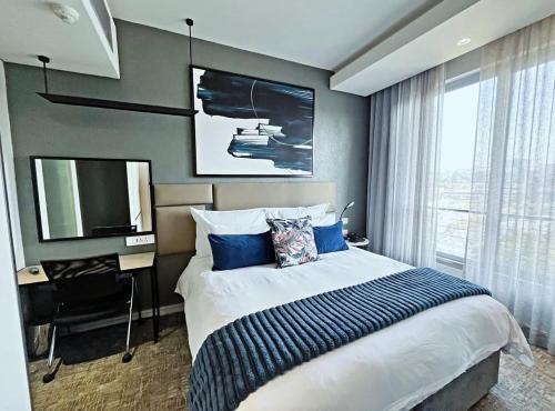 a bedroom with a large bed and a television at Stunning City View Apartment Sandton City in Johannesburg