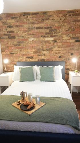 a bed with a tray of food on top of it at Stunning Brighton Seaside 2-Bedroom Townhouse with Patio, Sleeps 6 in Brighton & Hove