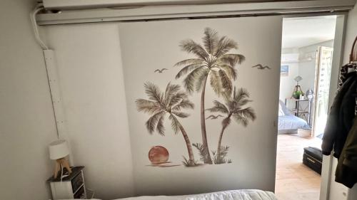 une fresque de palmiers sur un mur dans une chambre dans l'établissement Entre Lac, Mer et Montagne, au Barcarès