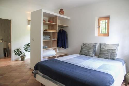 une chambre avec un lit et une étagère dans l'établissement Beautiful duplex apartment in a farmhouse in Provence Verte VAR, à Bras
