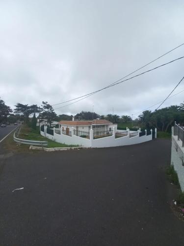 a house with a white fence on the side of a road at Airport Home Tenerife Norte in La Laguna