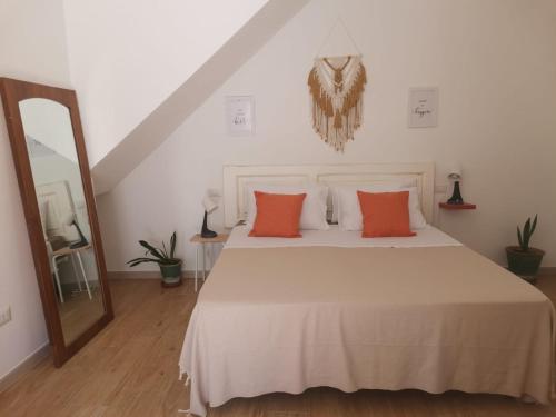 a bedroom with a white bed with orange pillows at Casa Camelia - Elegant Palace with Terrace - Conversano in Conversano