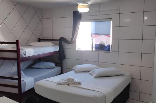 two bunk beds in a room with a window at Residencial Tia Antonia in Curitiba
