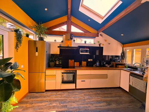 une cuisine avec des placards blancs et un plafond bleu dans l'établissement Le Surf Spot Capbreton, à Capbreton