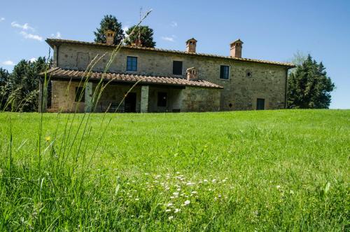 an old stone house in a field of grass at Chianti Classico Wine Resort Tenuta di Bibbiano - I Sodi in Castellina in Chianti