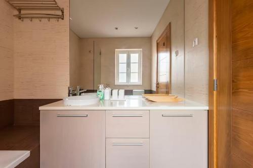 un bagno bianco con lavandino e specchio di Tower of Belém Premium Apartments A, B & C a Lisbona