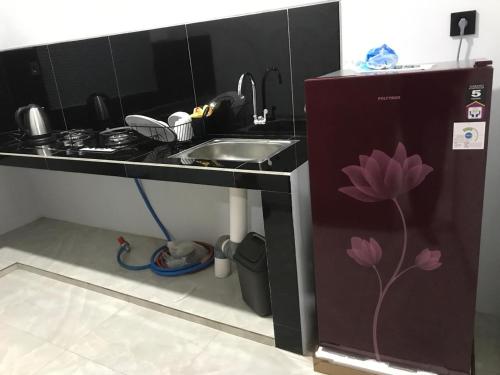 a small kitchen with a sink and a counter with a flower painted on it at Devarastra Villa #3 in Amed