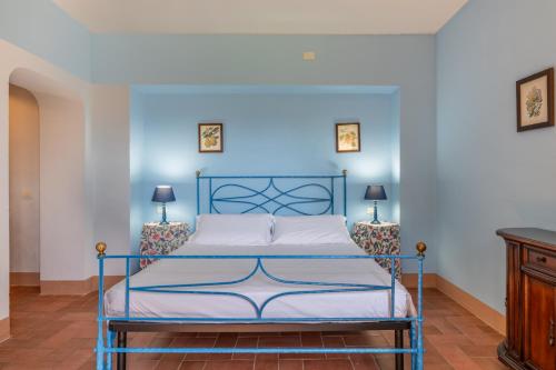 a blue bed in a room with two lamps at Chianti Classico Wine Resort Tenuta di Bibbiano - I Sodi in Castellina in Chianti