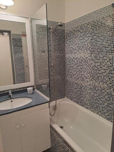 une salle de bain avec une baignoire, un lavabo et un miroir dans l'établissement Vue mer panoramique au Cap Esterel T2, à Saint-Raphaël