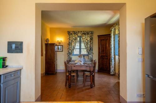 a dining room with a table and chairs and a window at Chianti Classico Wine Resort Tenuta di Bibbiano - I Sodi in Castellina in Chianti