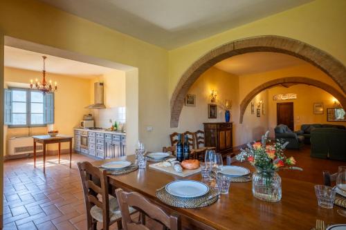 a dining room and living room with a wooden table at Chianti Classico Wine Resort Tenuta di Bibbiano - I Sodi in Castellina in Chianti