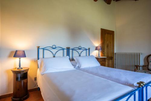 two twin beds in a bedroom with two lamps at Chianti Classico Wine Resort Tenuta di Bibbiano - I Sodi in Castellina in Chianti