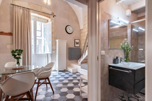 a bathroom with a table and chairs and a sink at Battisti Home - Lecce Selection in Lecce