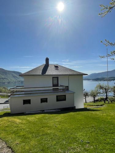 a white house with the sun in the sky at Retro hus med fin beliggenhet in Haddal