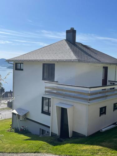 a white house with a roof on top of it at Retro hus med fin beliggenhet in Haddal