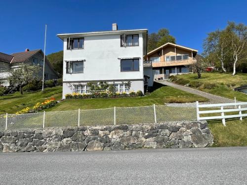 a white house on a hill with a fence at Retro hus med fin beliggenhet in Haddal