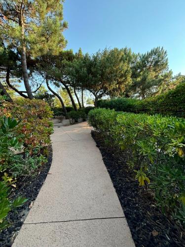 une passerelle dans un parc planté d'arbres et de buissons dans l'établissement Les maisons de Benedettu, à Lecci