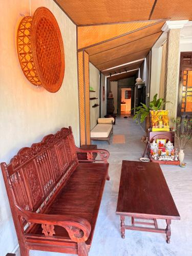 a living room with a wooden bench and a table at Ananda Home in Tân Hiệp