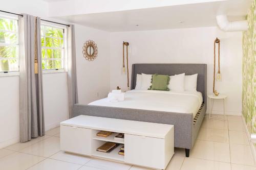 a white bedroom with a bed and a table at Miami River Inn by Renzzi in Miami