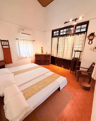 a bedroom with two beds and a chair at Ananda Home in Tân Hiệp