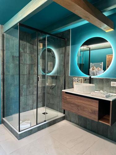 a bathroom with a shower with a sink and a mirror at La Mare aux Oiseaux, The Originals Collection in Saint-Joachim