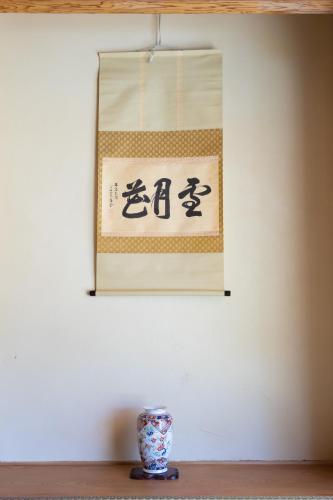 a sign hanging on a wall with a vase at HABi-Wakaura in Wakayama