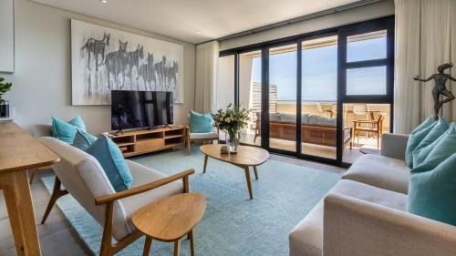 a living room with a couch and a television at The W-Collection Esplanade Hermanus in Hermanus