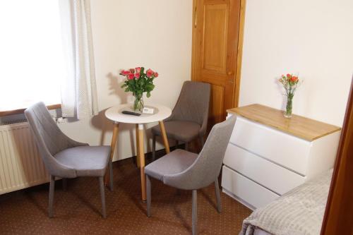 a room with a table and chairs and a table with flowers at Willa 1910 in Karpacz