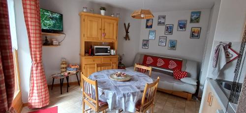une salle à manger avec une table et un canapé dans l'établissement Charmant F2 avec terrasse, un coin de paradis esprit montagnard, à Le Biot