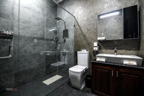 Un baño con ducha, inodoro y lavabo. en Madu River Reach, en Balapitiya