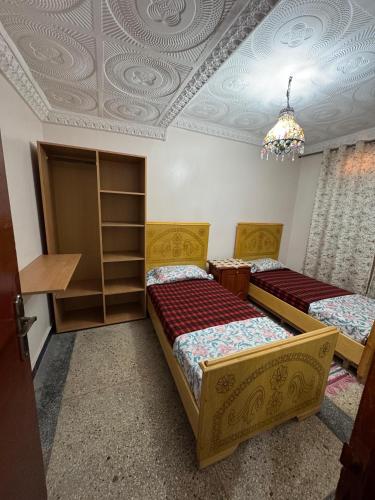 two beds in a room with a coffered ceiling at Appartement Atlas, Rue Mouatamid Ibn Abbad, Immeuble Malki, 1er étage, Oujda in Oujda