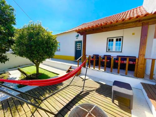 a hammock in front of a house at Casa da Laranjeira, perto de Obidos, Budha Eden, Dinossauros parque in Vale Covo