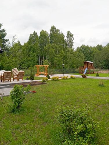 a park with a bench and a playground with at Domek letniskowy in Klusek Biały
