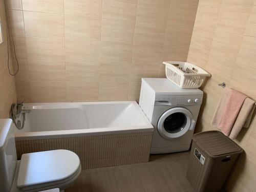 y baño con bañera y lavadora. en Spacious Apartment in Downtown City, en Il-Gżira