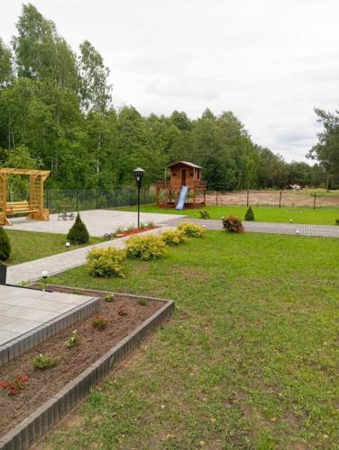 a park with a garden with flowers in the grass at Domek letniskowy in Klusek Biały