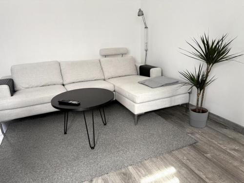 a living room with a white couch and a table at Nyrenoverat lägenhet i Halmstad in Halmstad