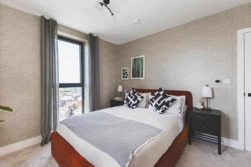 a bedroom with a large bed and a window at Stunning Premium 2 Bed Flat with Great Views - Rooftop on Top Floor in Croydon