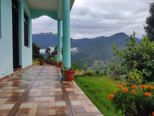 a porch of a house with a view of mountains at Nanda Devi Home Stay in Sari