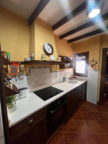 a kitchen with a sink and a clock on the wall at Casa Martijo in Taramay