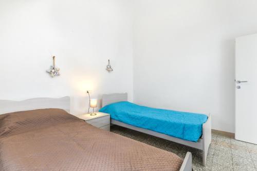 a bedroom with two beds and a blue blanket at Cesarina Trilo in Marciana