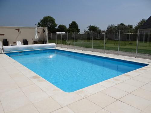 une grande piscine bleue dans une cour dans l'établissement Gîte bord de mer près de FECAMP 