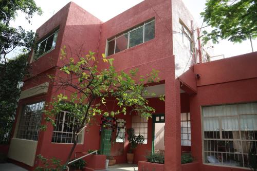 a red building with a tree in front of it at Casa Artemisa hostal in Guadalajara