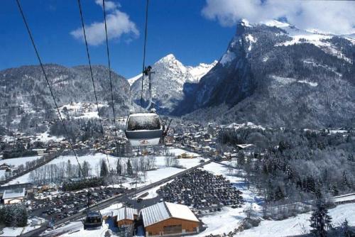 a ski lift over a town in the snow at Chalet Tomsine in Samoëns