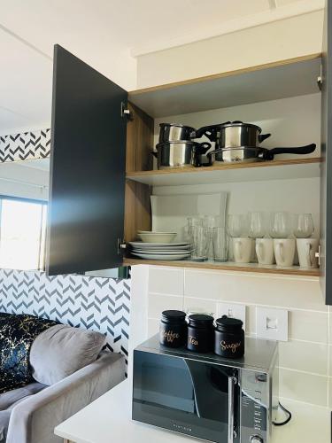 a kitchen with a microwave oven with pots and pans at The Lagoon in Pretoria