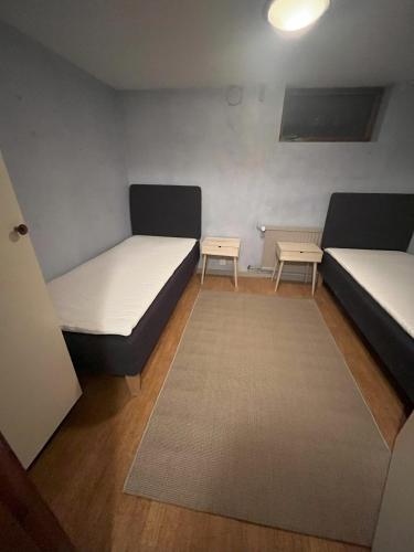 a small room with two beds and a rug at Källarlägenhet - Enkelt boende in Båstad